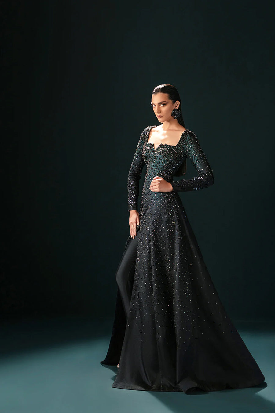 Model in a front shot wearing a formal black front-slit open gown made of organza paired with silk pants