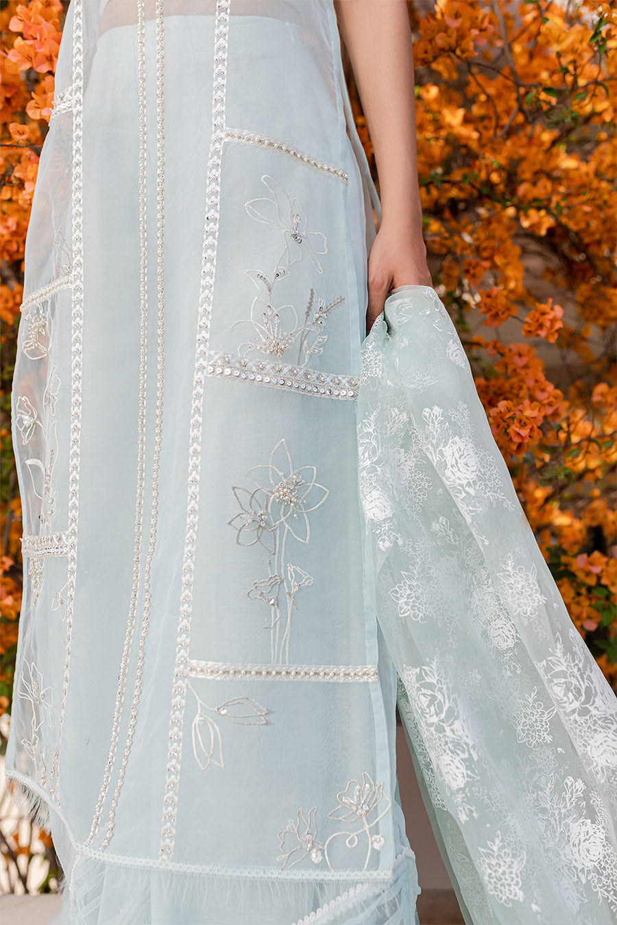 model in a closeup shot wearing a formal blue organza shirt