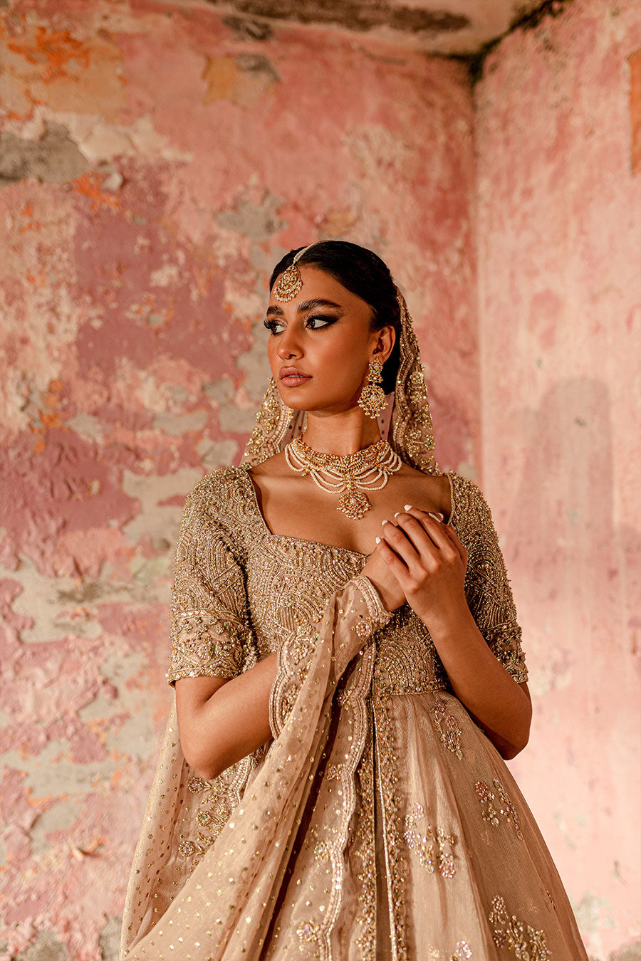 Model wearing a blush pink masuri and organza zari bridal dress by Zuria Dor with front slit pishwas