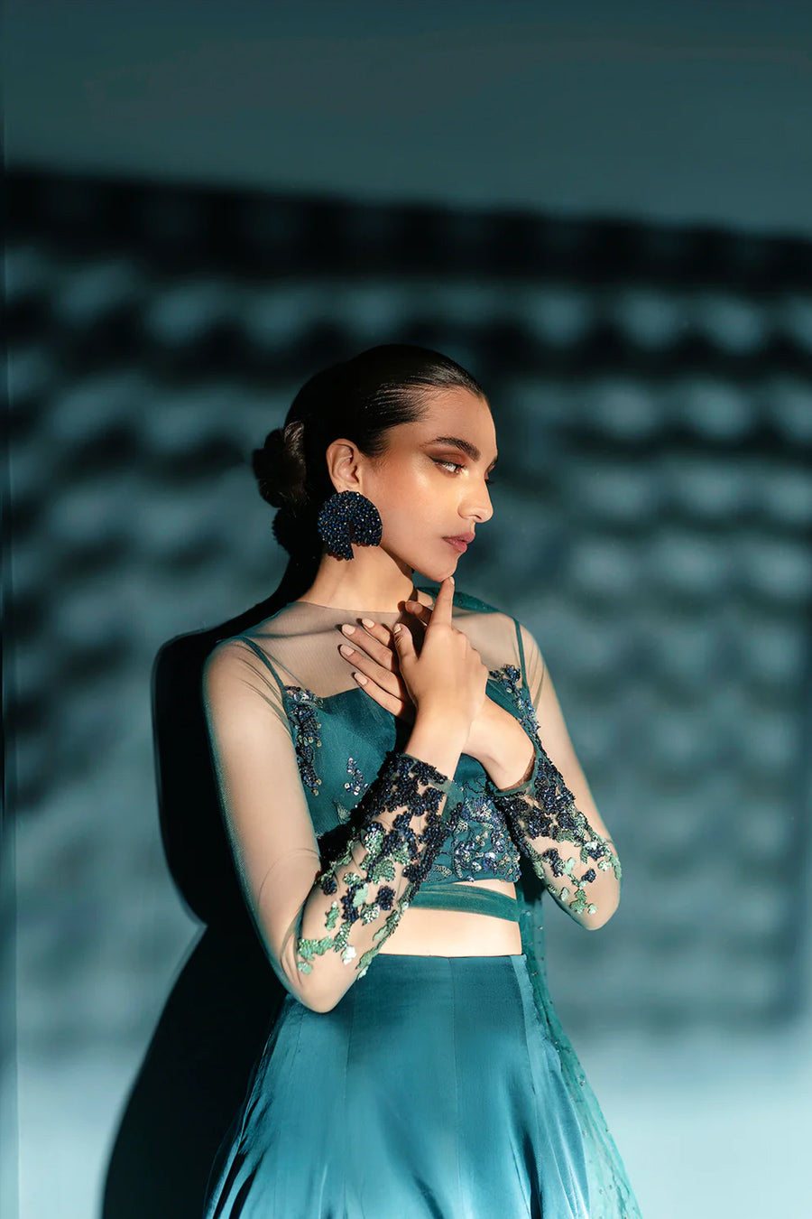 Model in a closeup shot wearing sea green formal lehenga choli with net drape attached