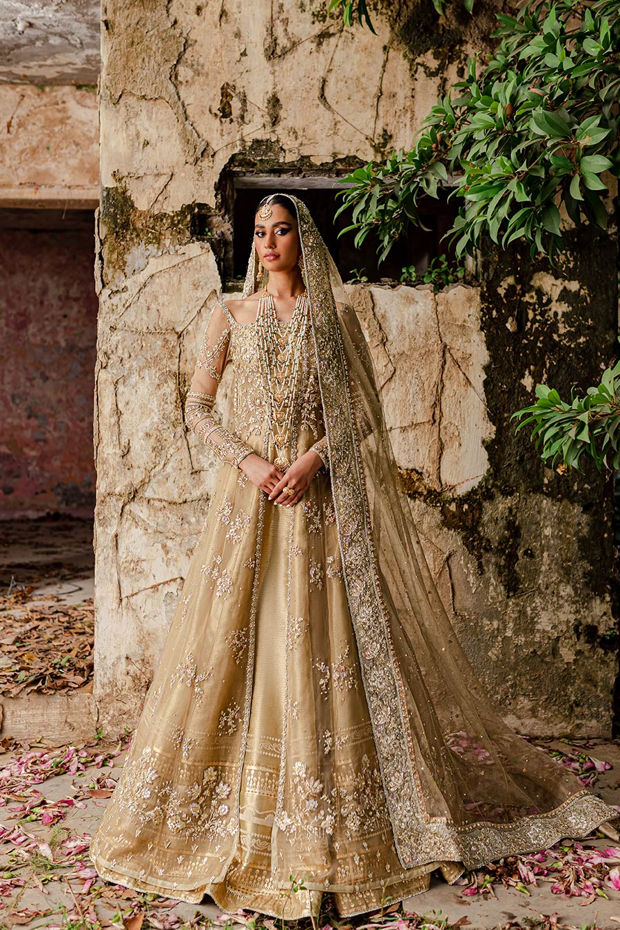 Model wearing a golden front slit organza with zardozi and gota detailing bridal dress by Zuria Dor with front slit shirt