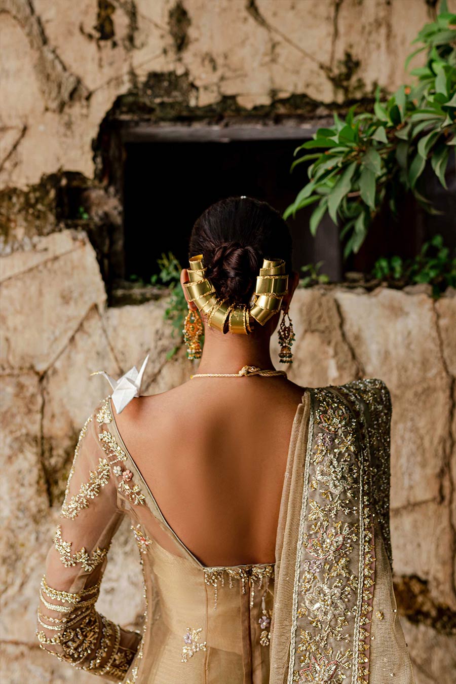 Model wearing a warm peach bridal lehenga dress with thread work, zardozi, and sequin embellishments by Zuria Dor