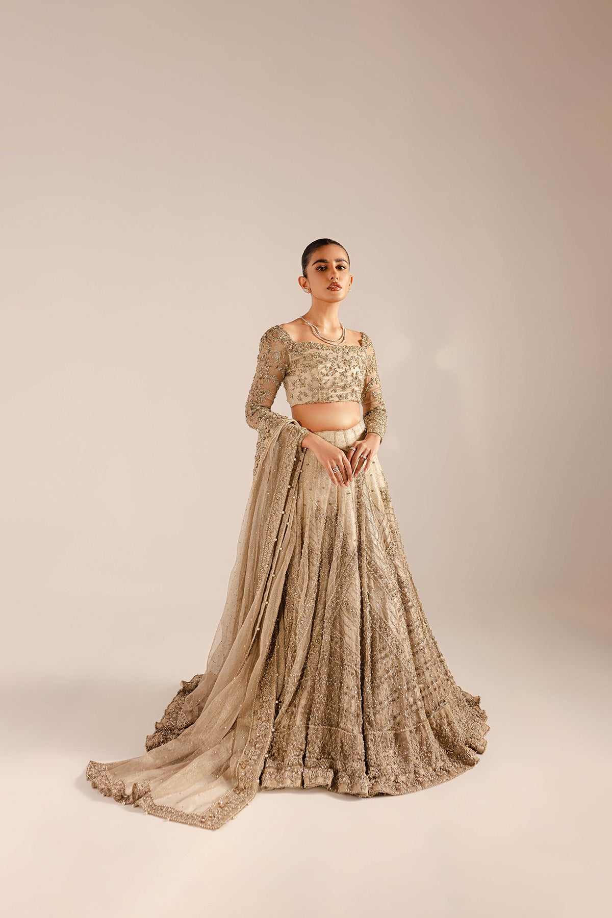 Model in a front shot wearing a kundan net lehenga and choli with a kundan net dupatta with embellished borders