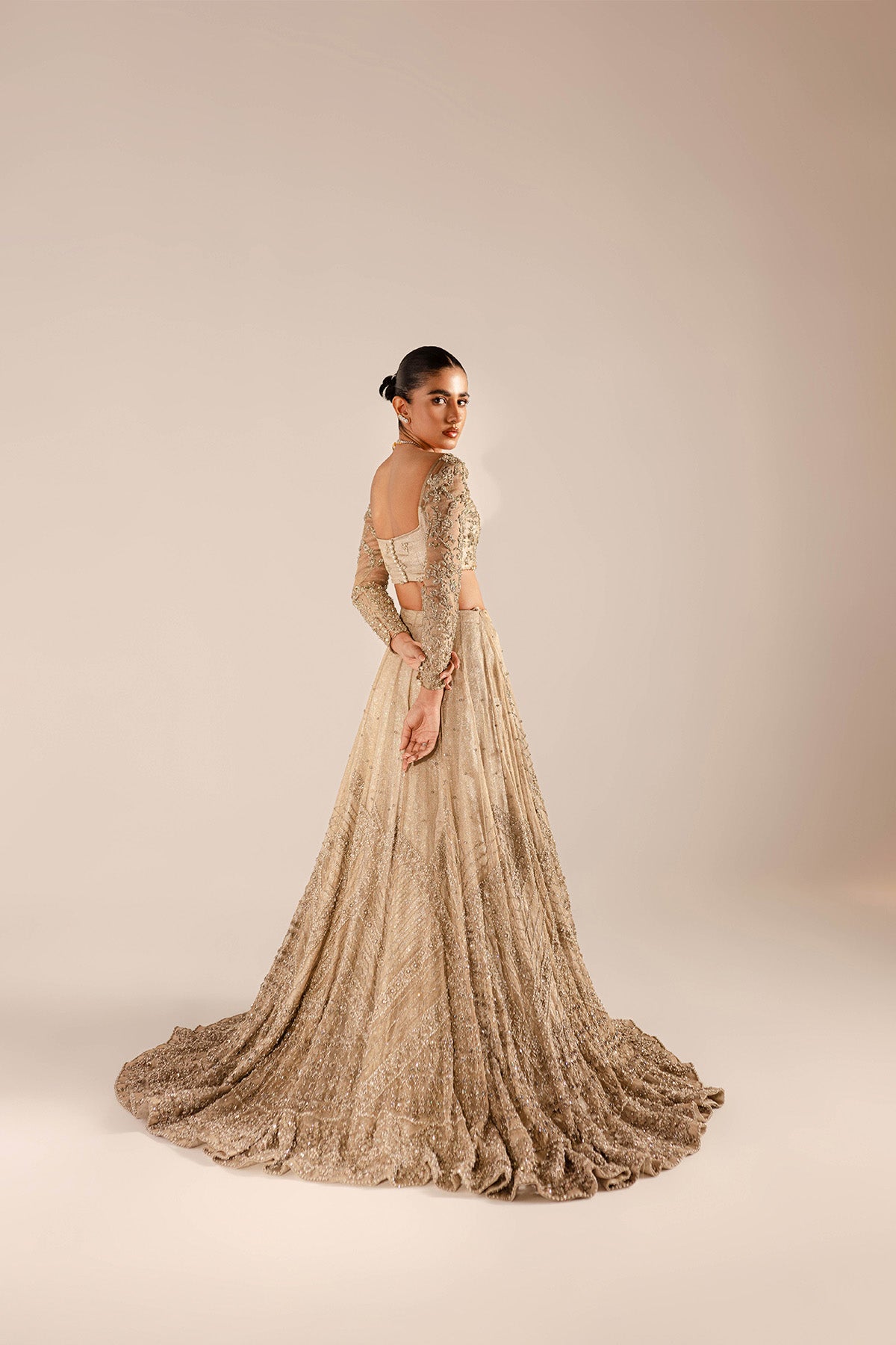 Model in a back shot wearing a kundan net lehenga and choli