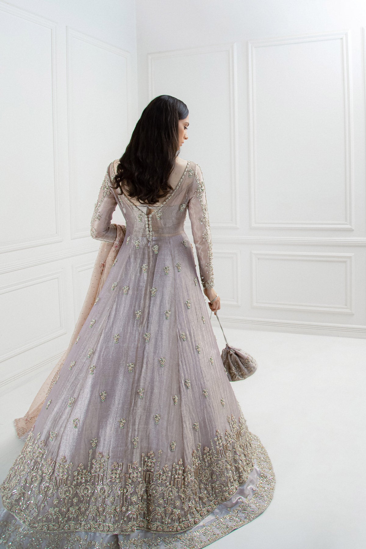 model in a back shot wearing bridal paneled lilac tissue shirt paired with a shimmer tissue lehenga along with an organza dupatta
