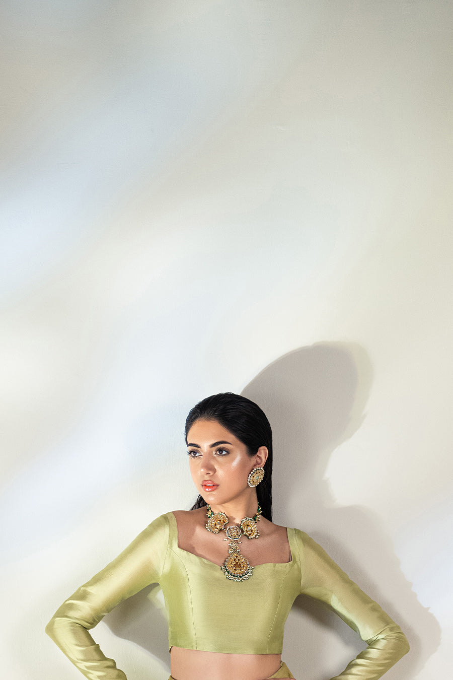 model in a back shot wearing a formal lime green lehenga paired with a solid choli and dupatta