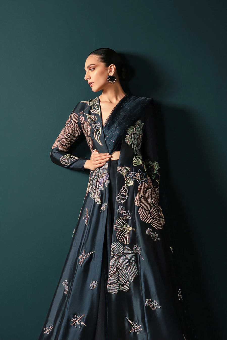 Model in a close up shot wearing a midnight blue formal silk jacket paired with a bustier and skirt