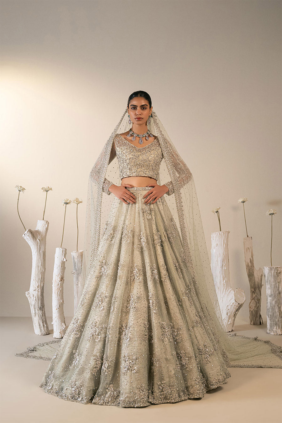 Model in a front shot wearing mint green bridal lehenga choli paired with net veil