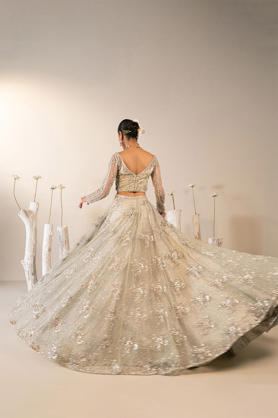 Model in a side shot wearing mint green bridal lehenga choli paired with net veil
