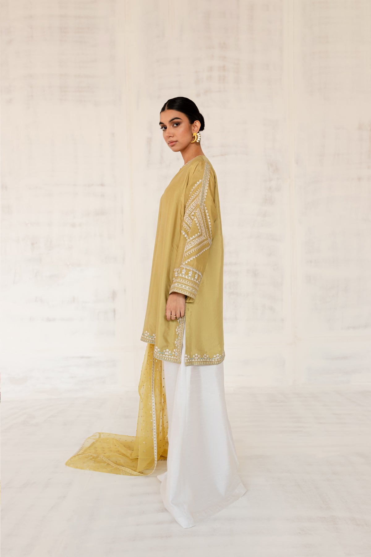 Model in a side facing shot wearing Cotton silk shirt with silk pants and organza dupatta