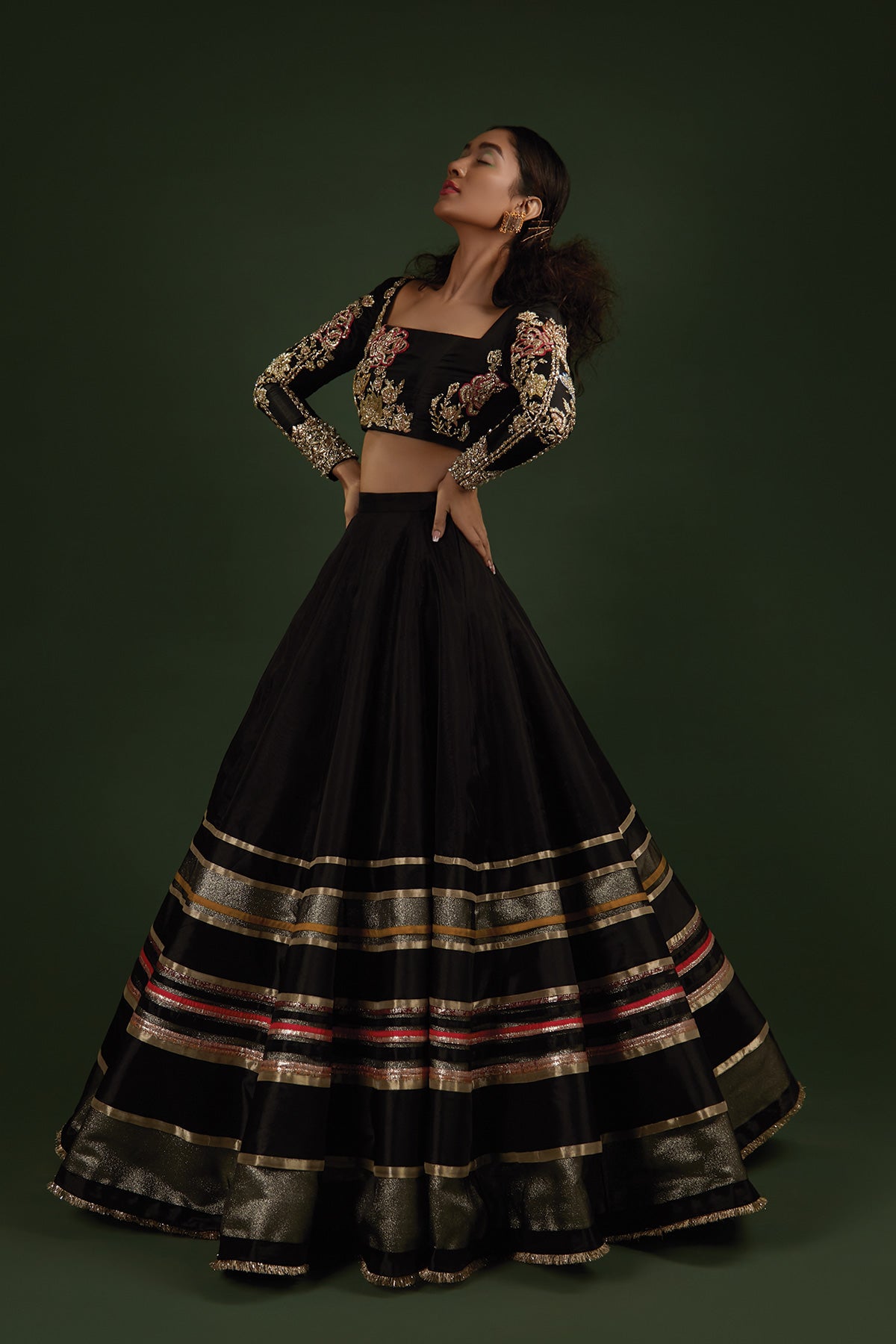 Model in a side shot wearing black lehenga choli made of katan silk paired with a black lehenga
