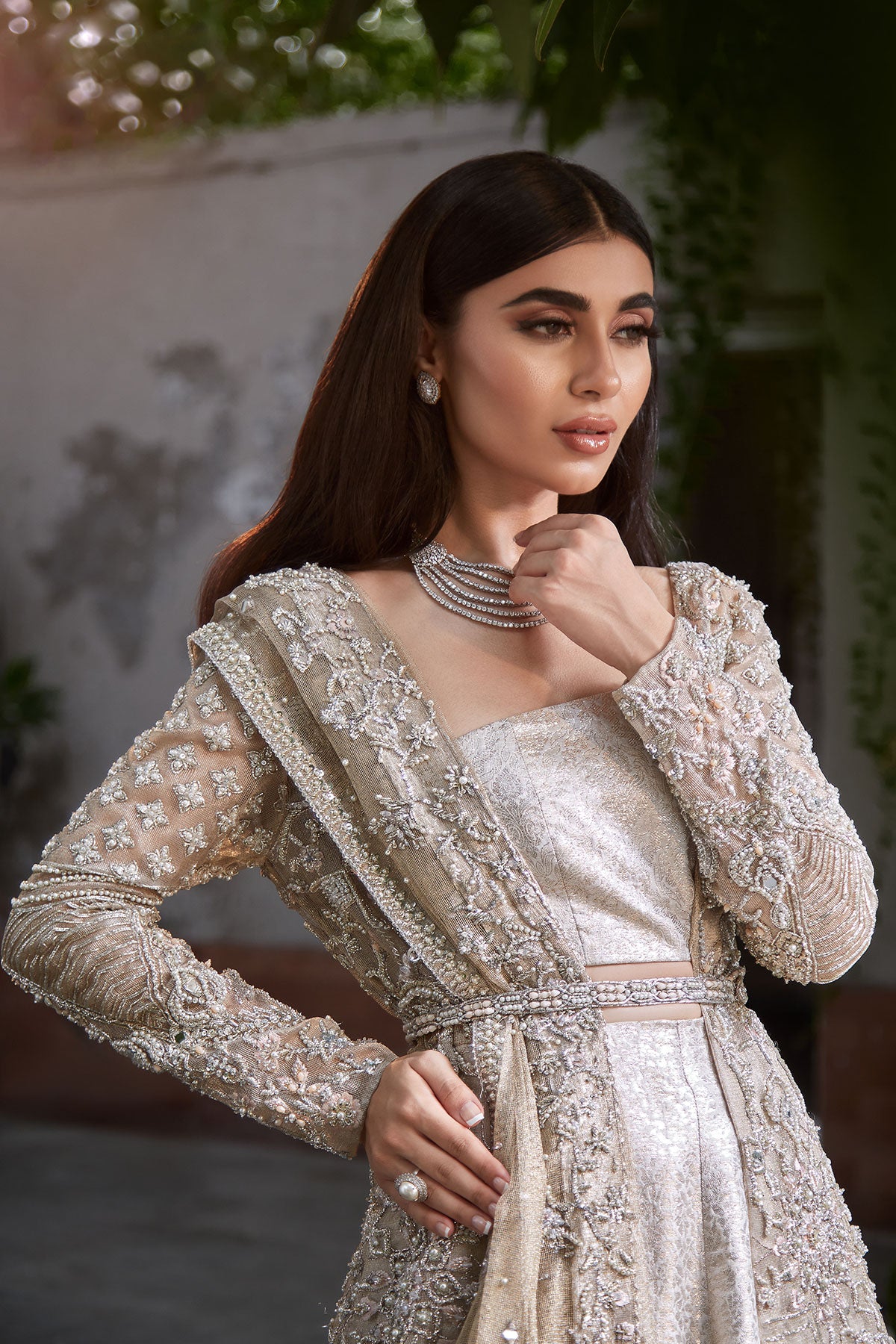 model in a closeup shot wearing bridal kundan net front-open long gown paired with a brocade bustier and lehenga and dupatta