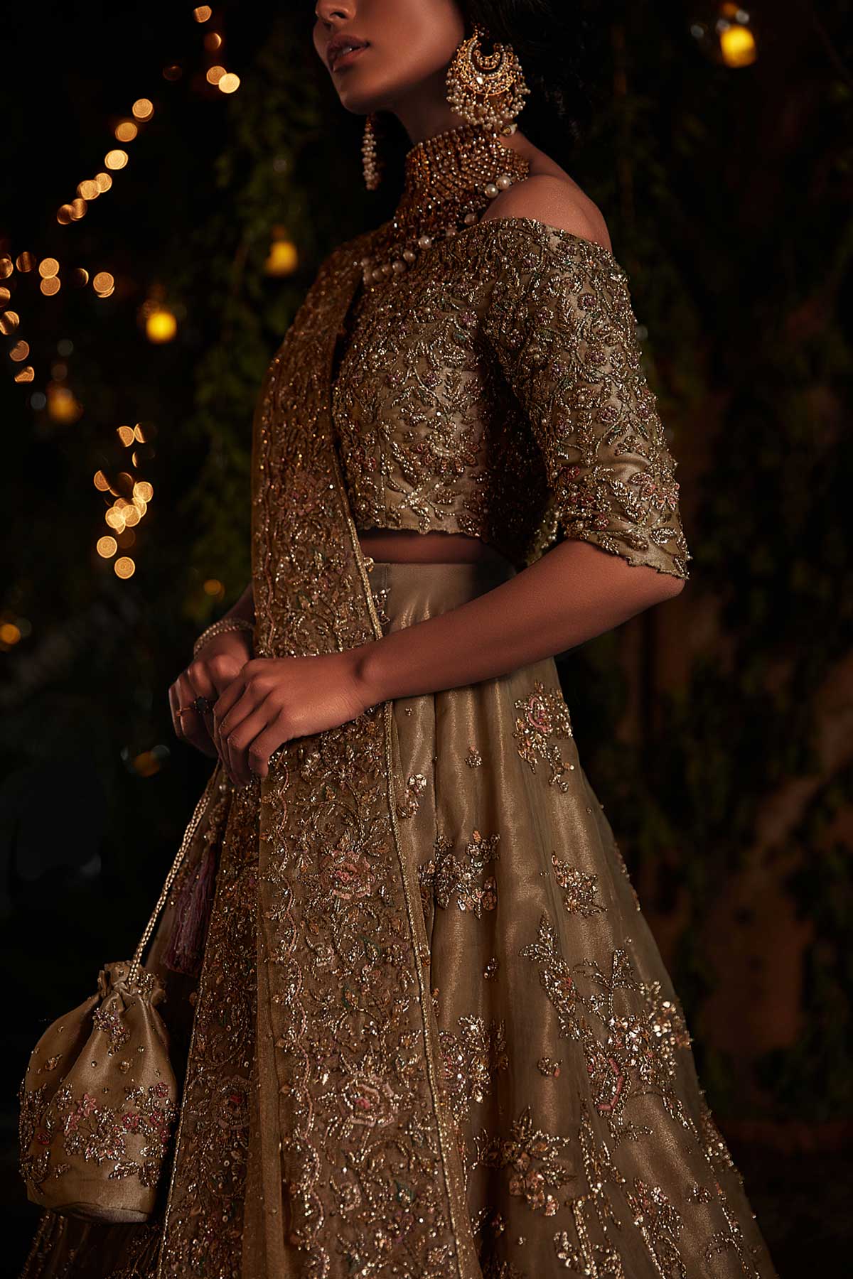 model in a close shot wearing a bridal olive green lehenga paired with off-shoulder choli and zari net dupatta