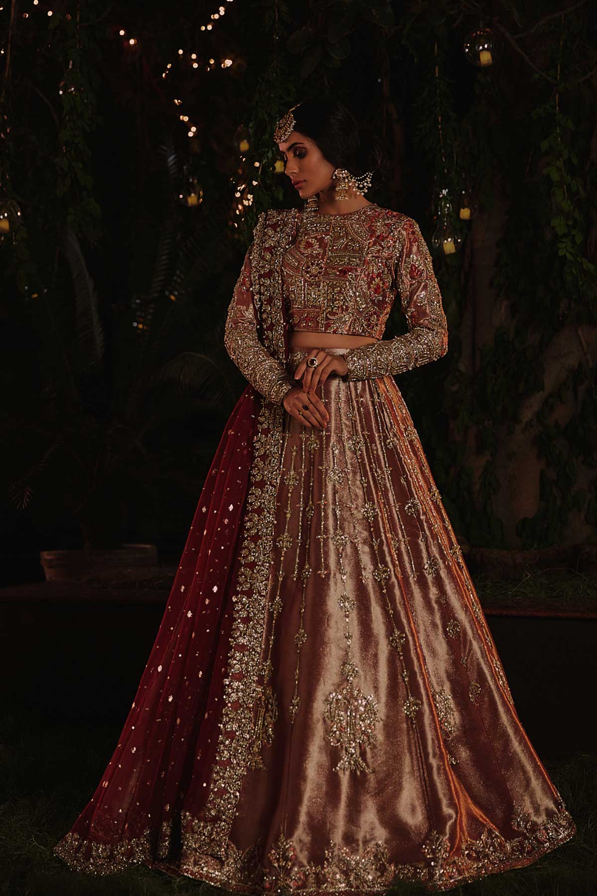 model in a front shot wearing rust-colored bridal lehenga choli crafted in tissue fabric and silk organza dupatta