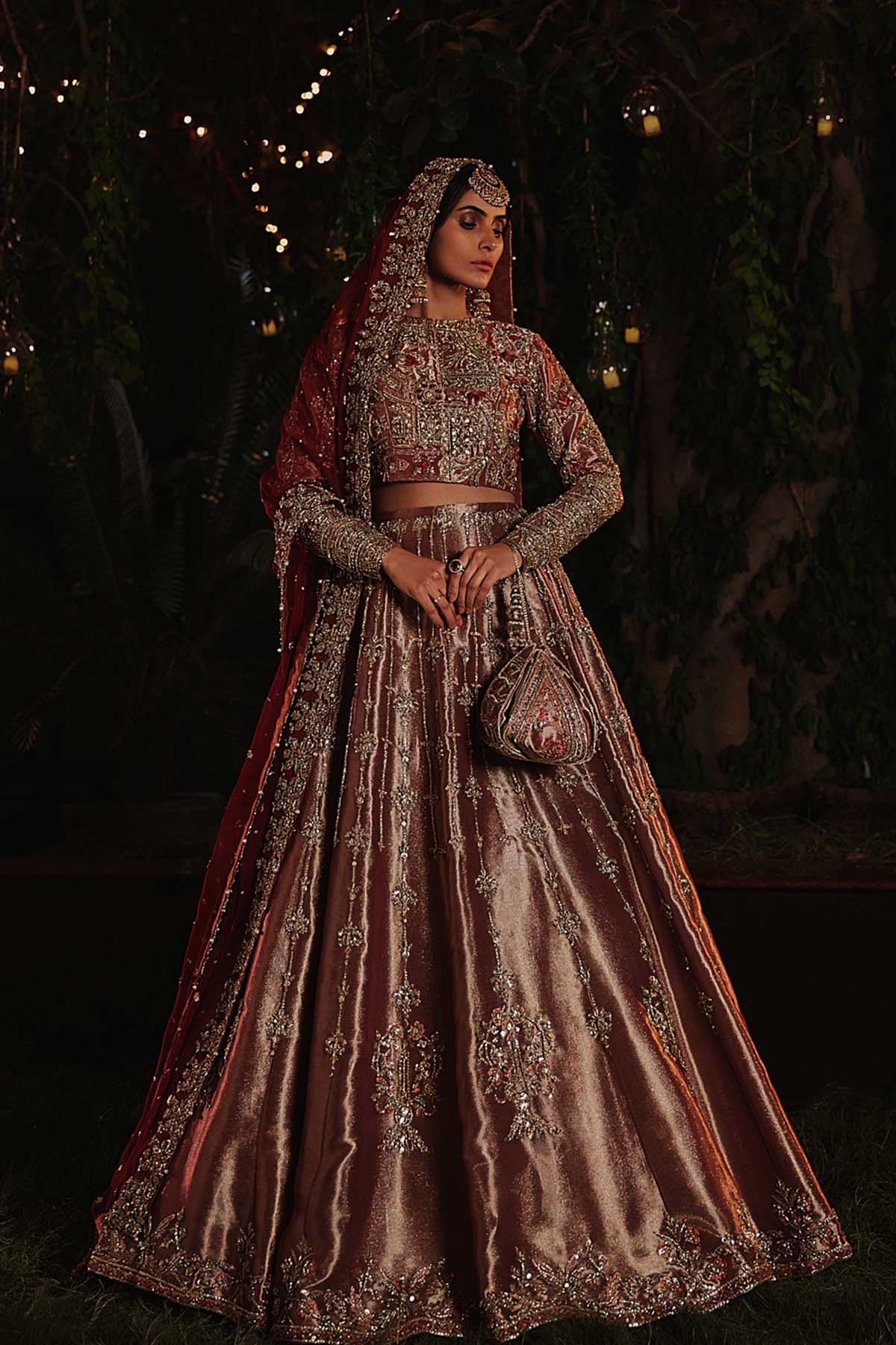 model in a front shot wearing rust-colored bridal lehenga choli crafted in tissue fabric and silk organza dupatta