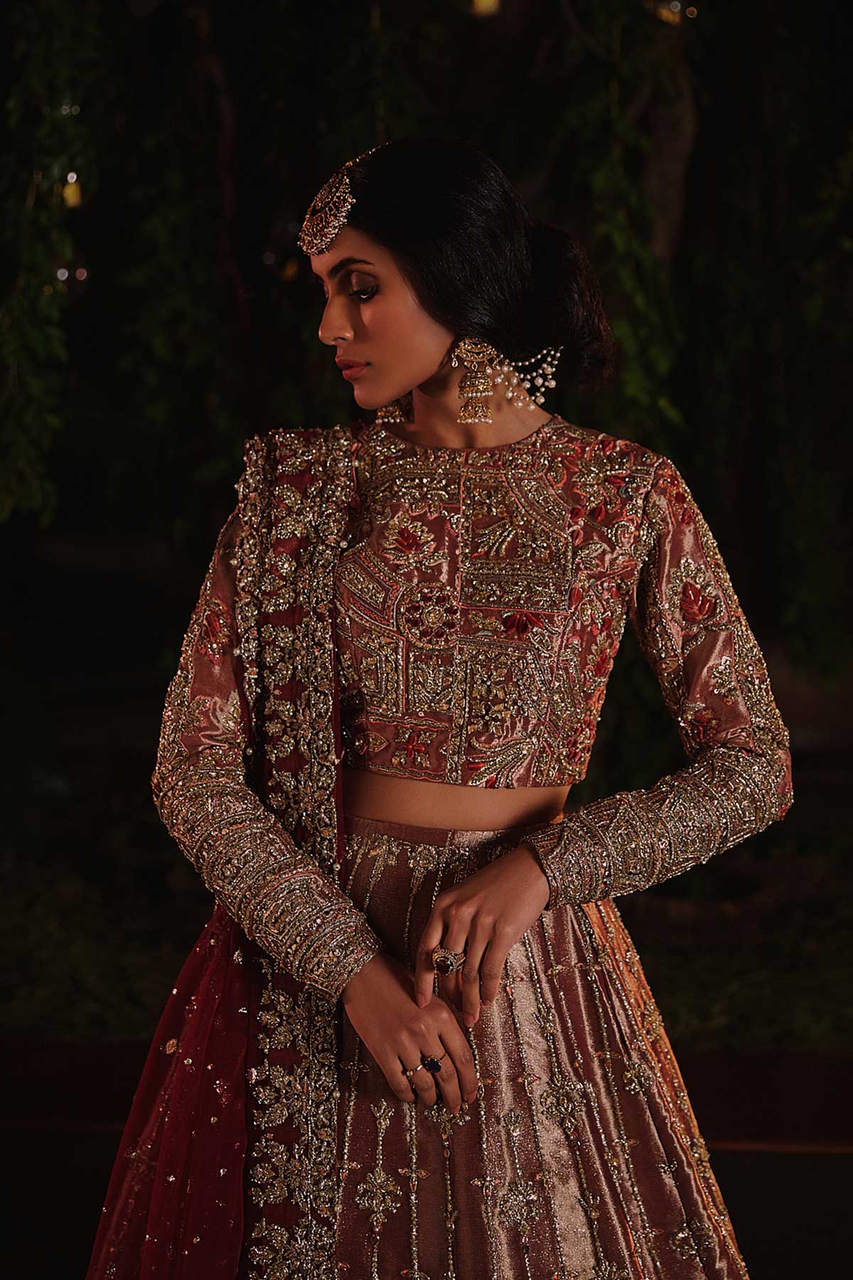 model in a front closeup shot wearing rust-colored bridal lehenga choli crafted in tissue fabric and silk organza dupatta