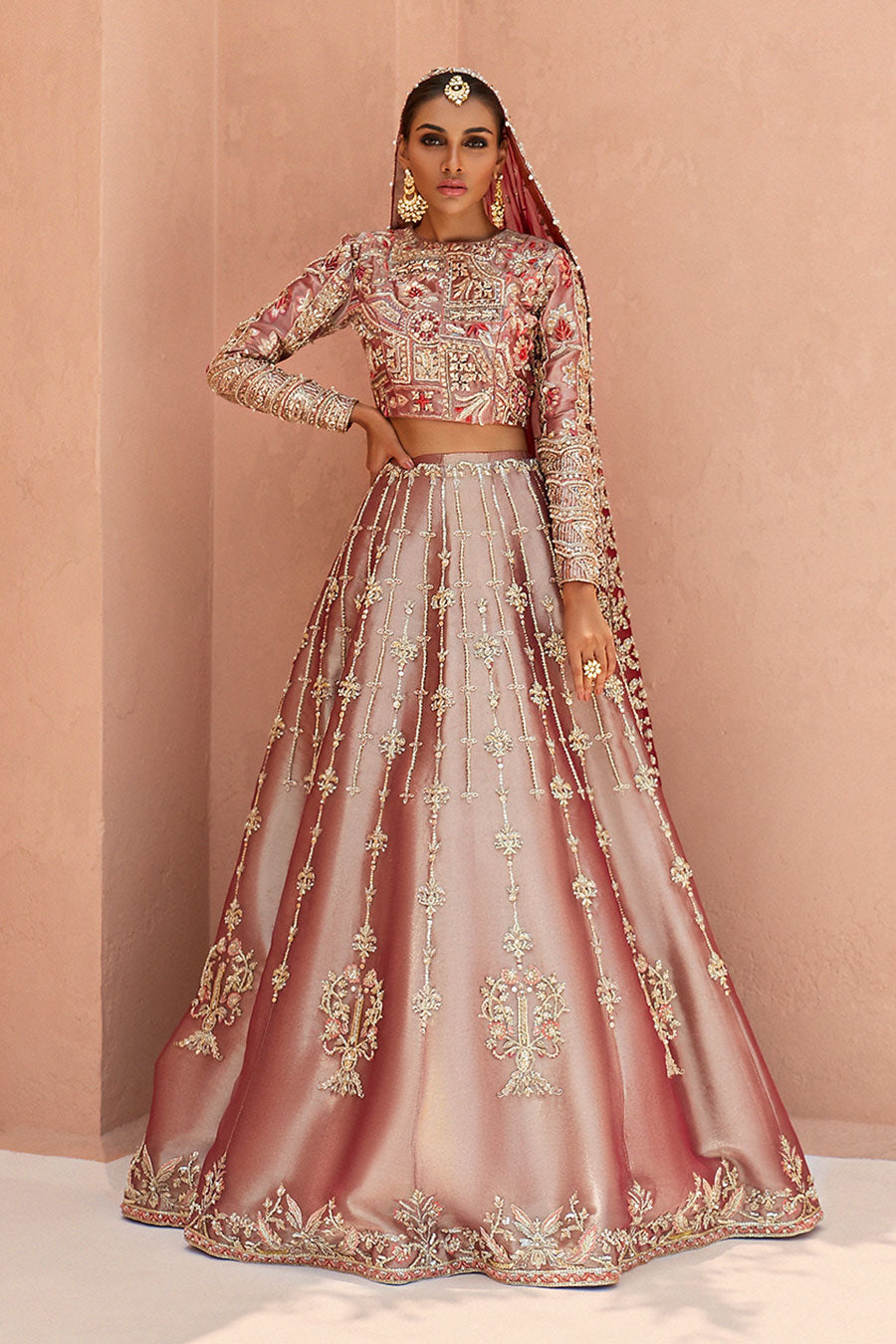model in a front shot wearing rust-colored bridal lehenga choli crafted in tissue fabric and silk organza dupatta