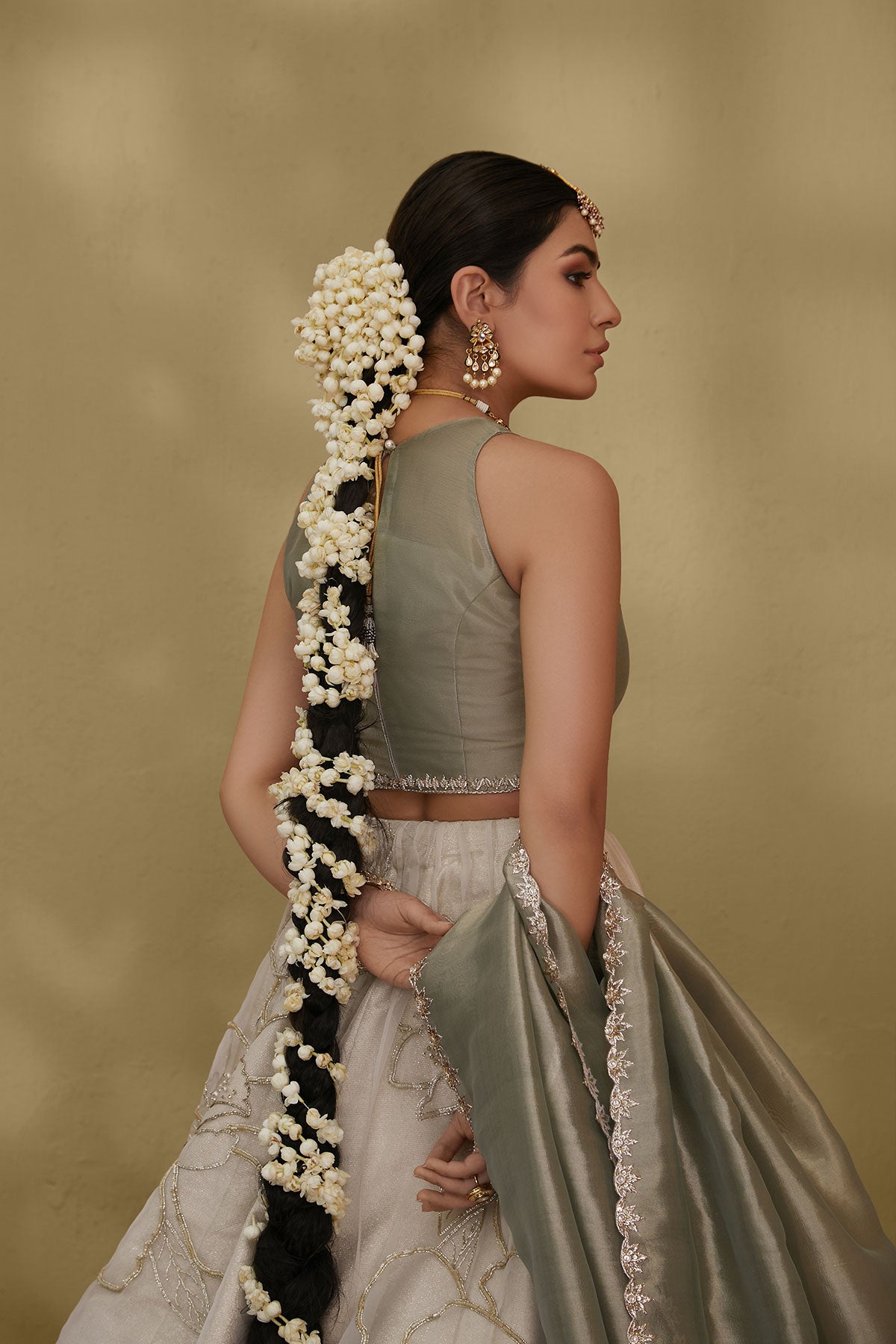 Model in a closeup shot wearing white organza skirt paired with green tissue blouse and an embroidered tissue dupatta