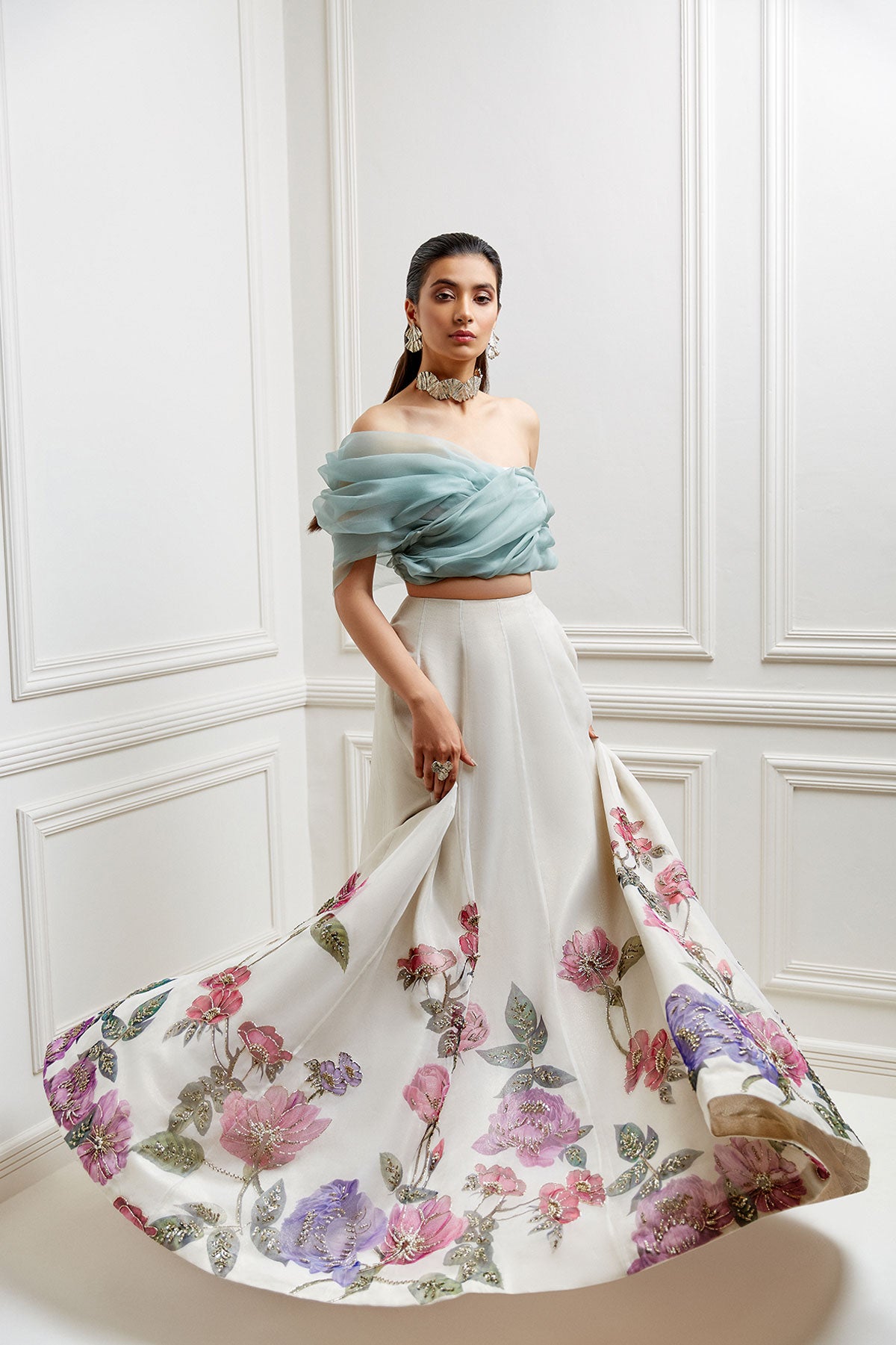 model in a front shot ivory, hand-painted floral organza skirtp aired with an off-shoulder organza blouse