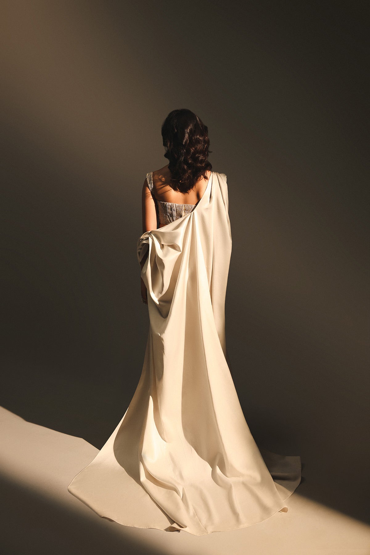Woman in a flowing white garment against a dark background