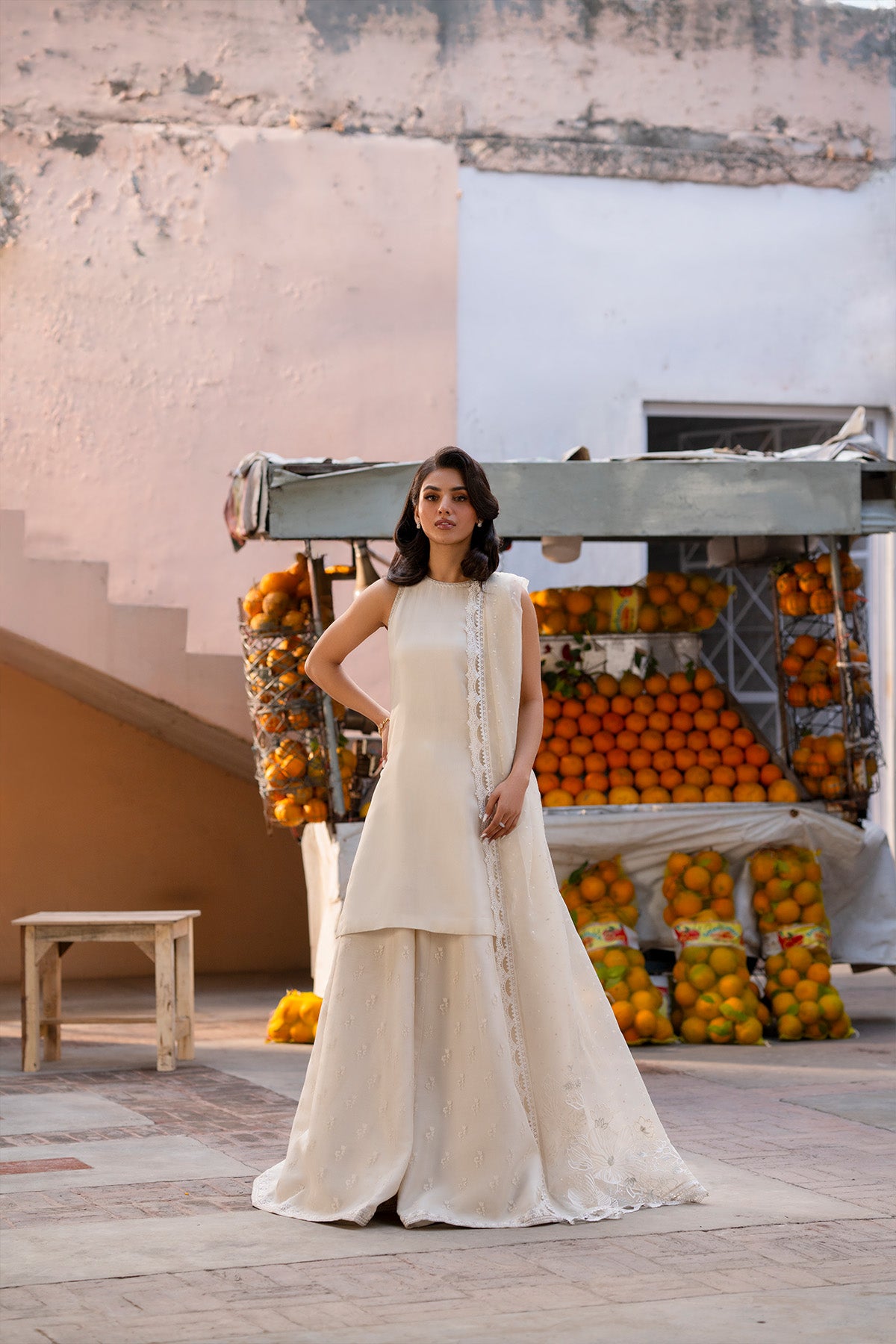 Model in a front shot wearing a beige silk shirt paired with screen-printed organza sharara pants.