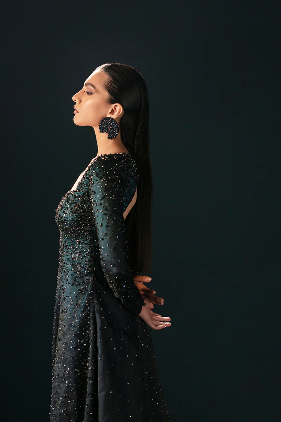 Model in a closeup side shot wearing a formal black front-slit open gown made of organza