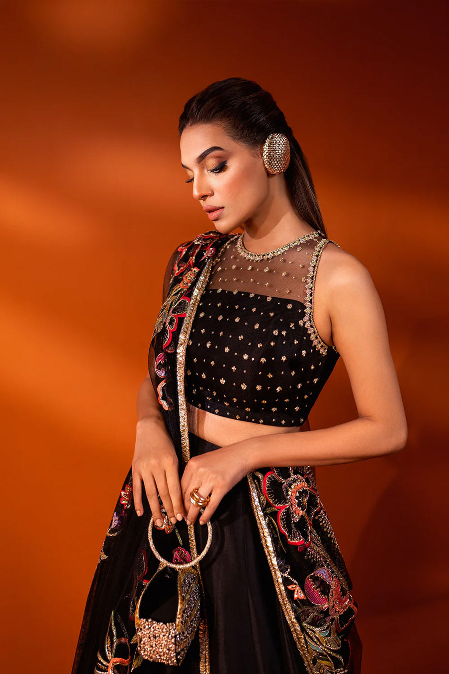 model in a closeup shot wearing formal black net dupatta paired with net blouse and a  silk lehenga