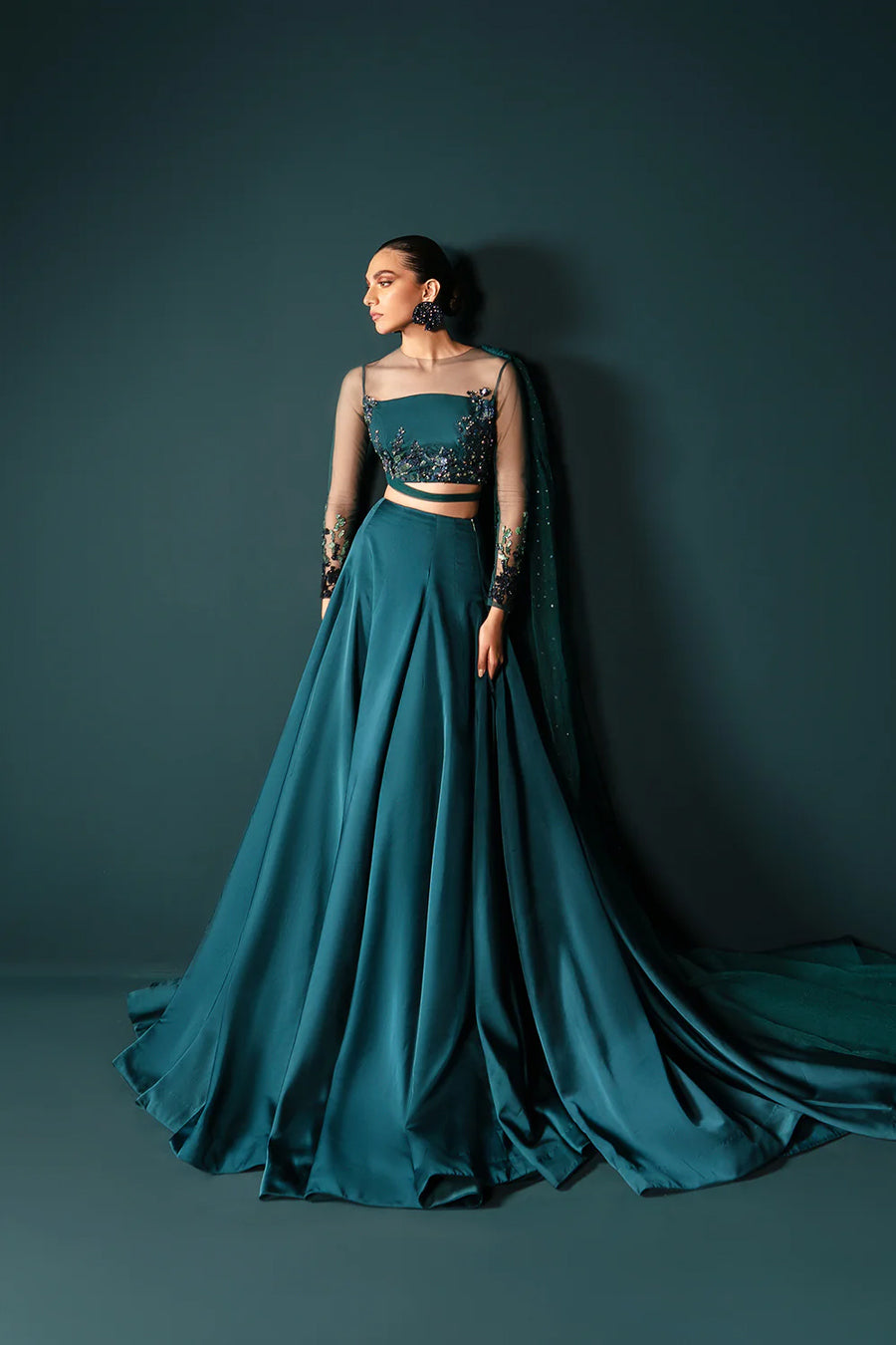 Model in a front shot wearing sea green formal lehenga choli with net drape attached