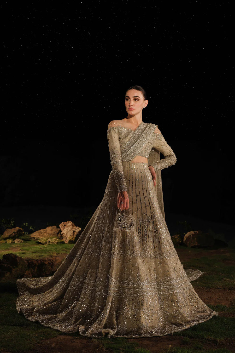 Model in front side shot wearing a gold and silver bridal lehenga with a train and an attached drape