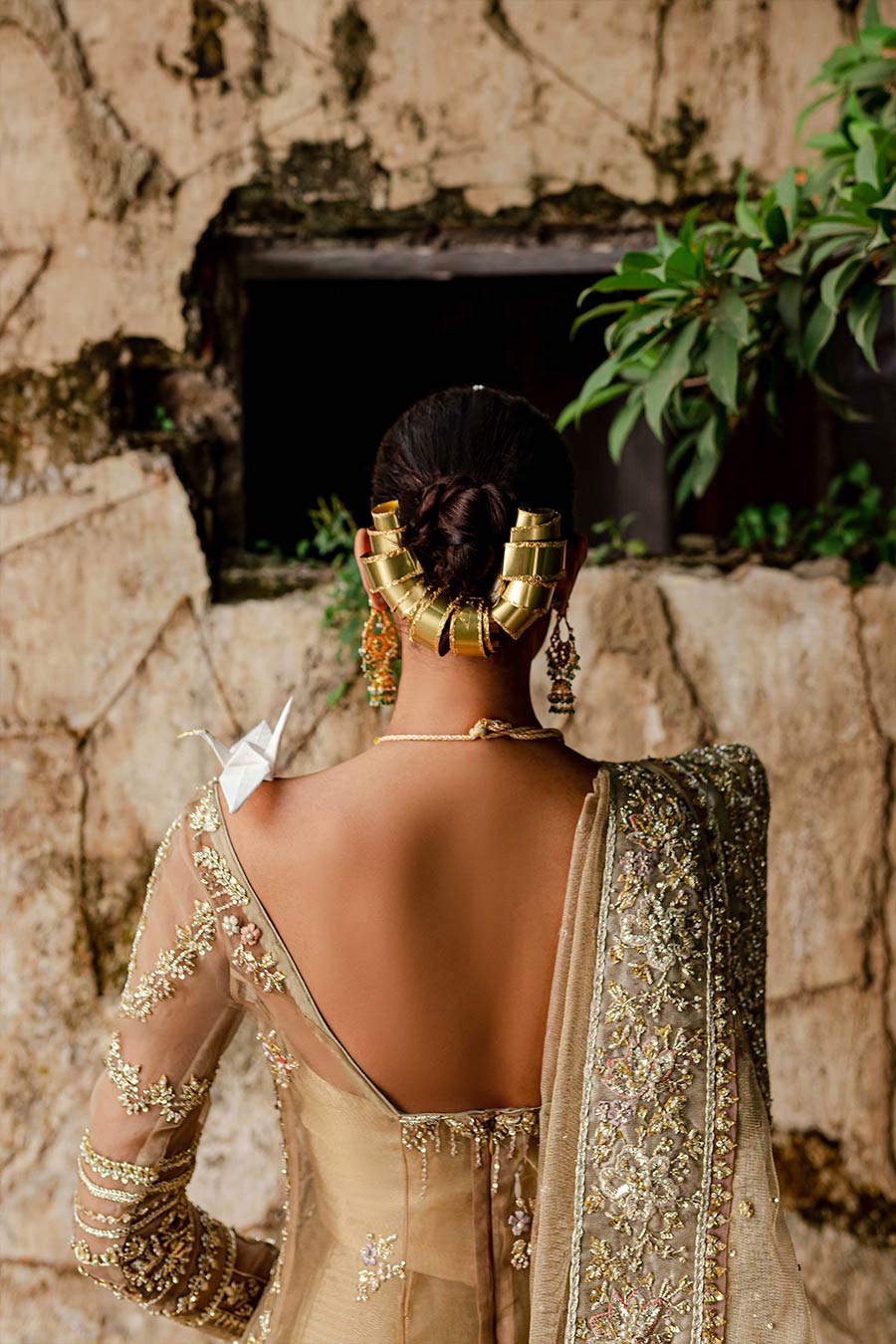 Model wearing a warm peach bridal lehenga dress with thread work, zardozi, and sequin embellishments by Zuria Dor 