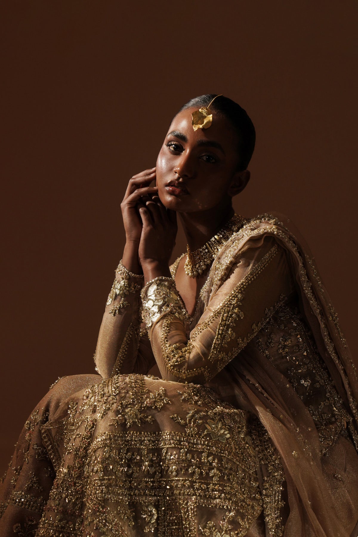 Model in a front shot wearing a golden tissue bridal shirt paired with a crushed tissue and zari net dupatta