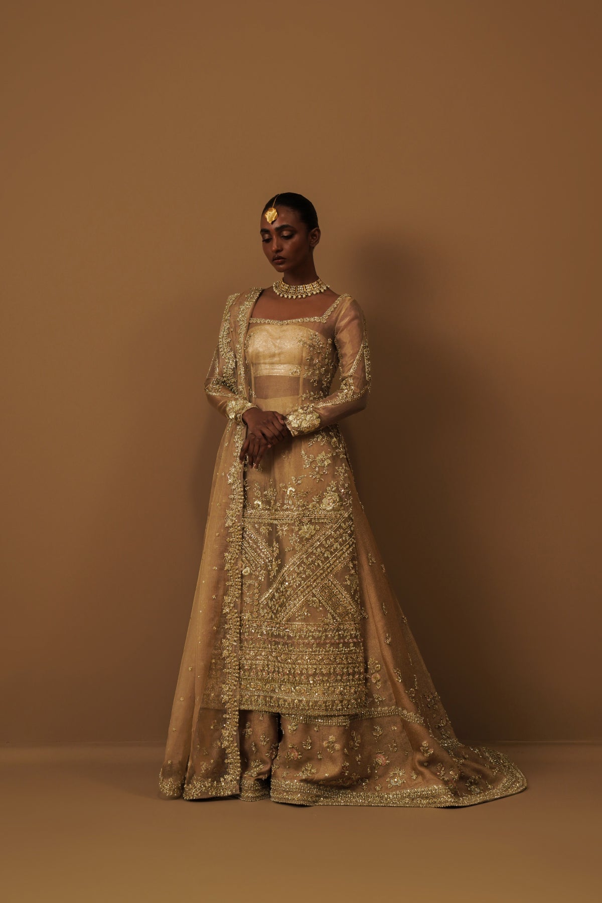 Model in a front shot wearing a golden tissue bridal shirt paired with a crushed tissue dupatta