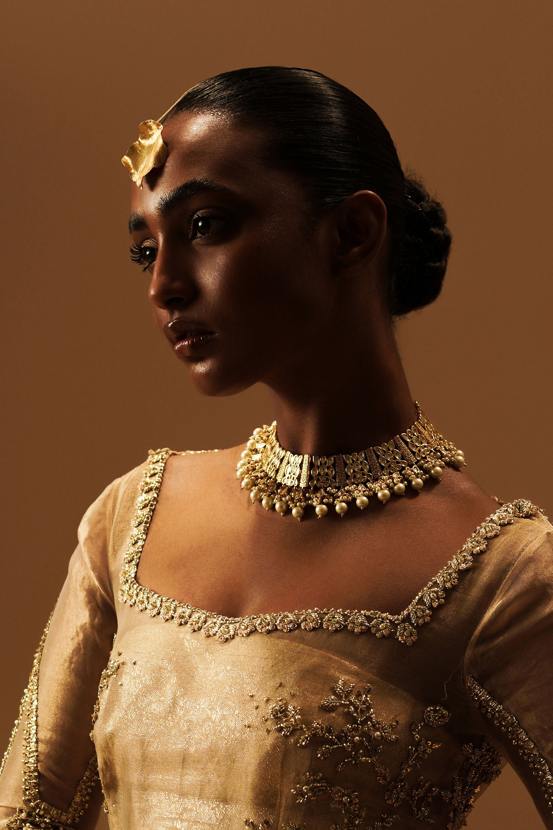 Model in a closeup shot wearing golden tikka