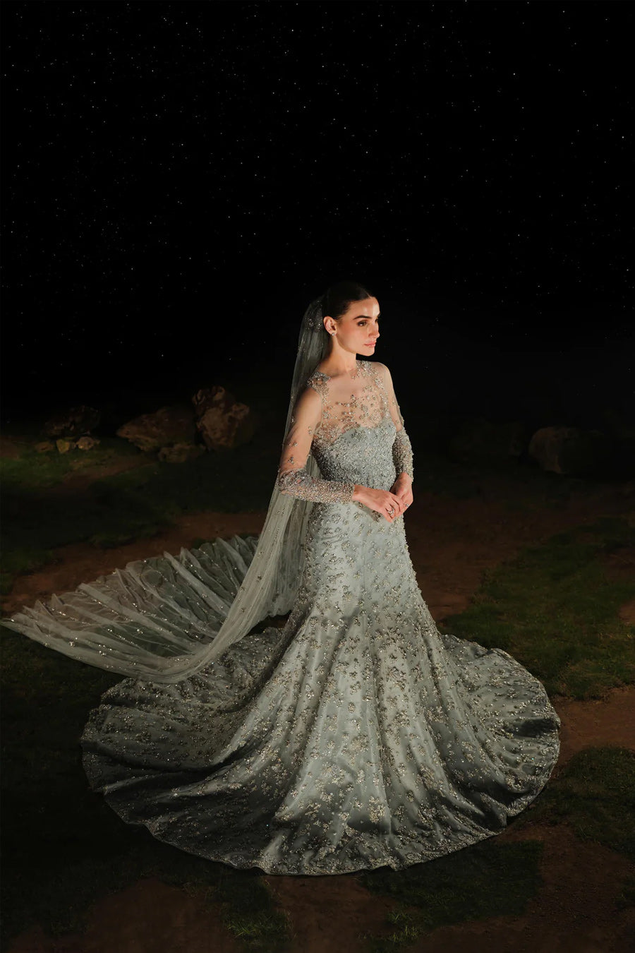 Model in a top shot wearing a ice-blue bridal gown paired with trailing veil