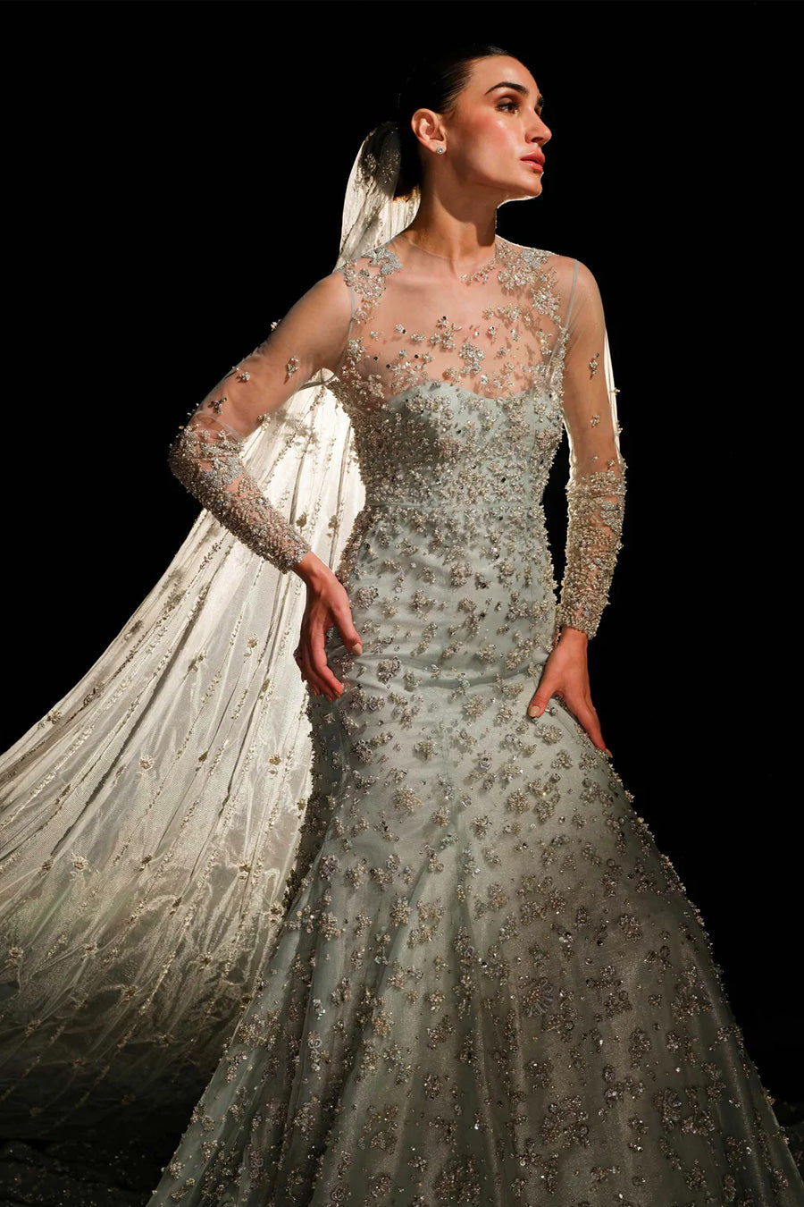 Model in a front closeup shot wearing a ice-blue bridal gown paired with trailing veil