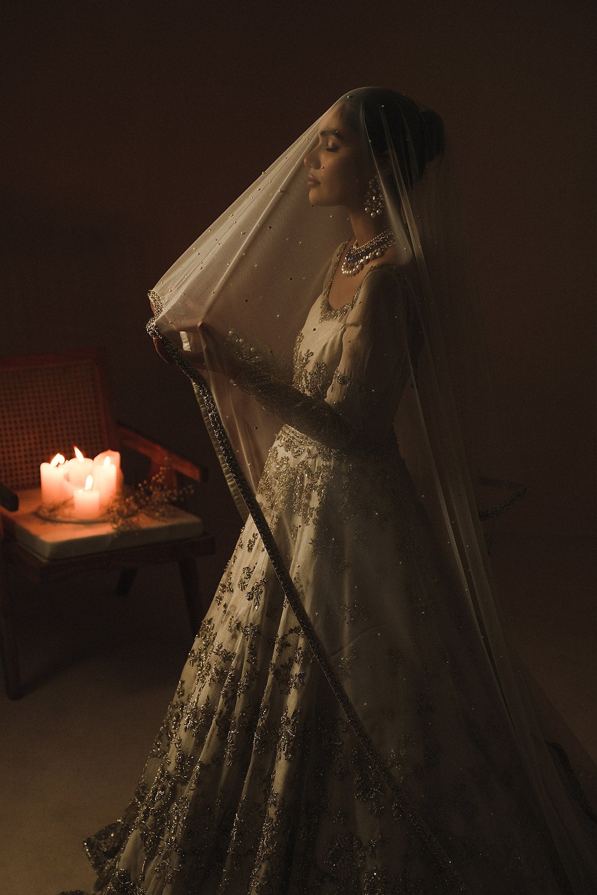 Aidaah Sheikh in a side shot wearing ivory gown with zardozi and sequin work all over paired with a zari net dupatta 