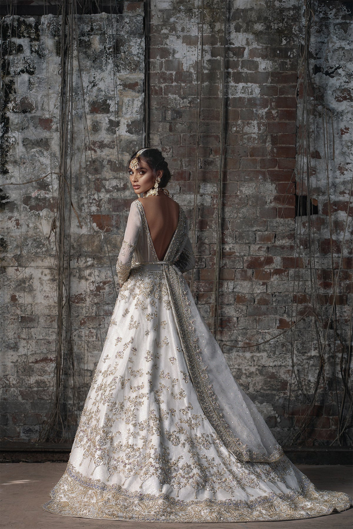 Aidaah Sheikh in a backview shot wearing ivory gown with zardozi and sequin work all over paired with a zari net dupatta 