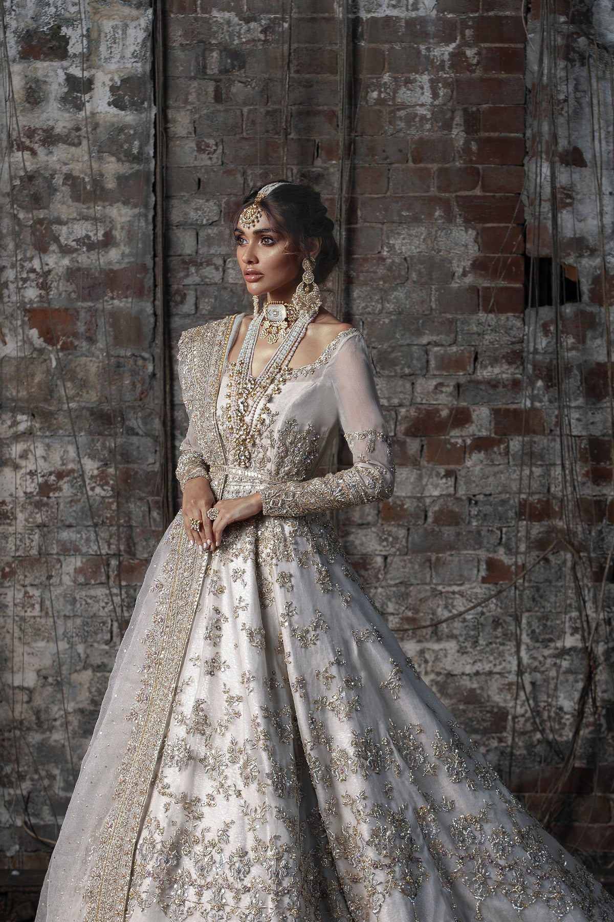 Aidaah Sheikh in a side view shot wearing ivory gown with zardozi and sequin work all over paired with a zari net dupatta 