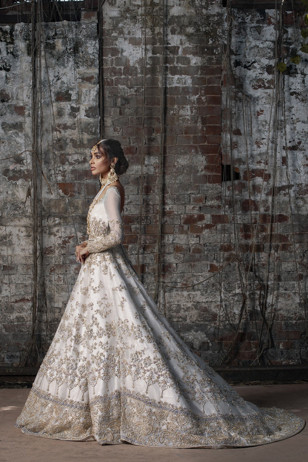 Aidaah Sheikh in a side view shot wearing ivory gown with zardozi and sequin work all over paired with a zari net dupatta 