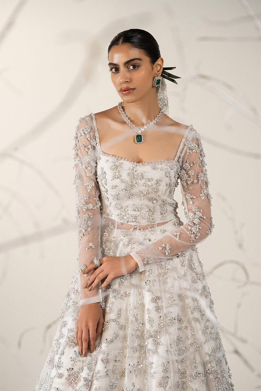 Model in a front closeup shot wearing ivory bridal net pishwas paired with organza lehenga and a net veil