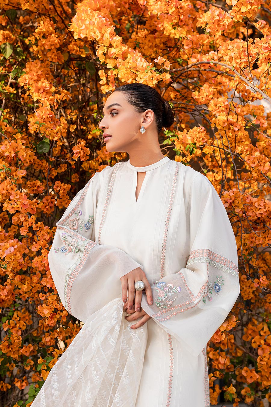 model in a closeup shot wearing a formal organza kurta paired with raw silk cigarette pants and printed organza dupatta