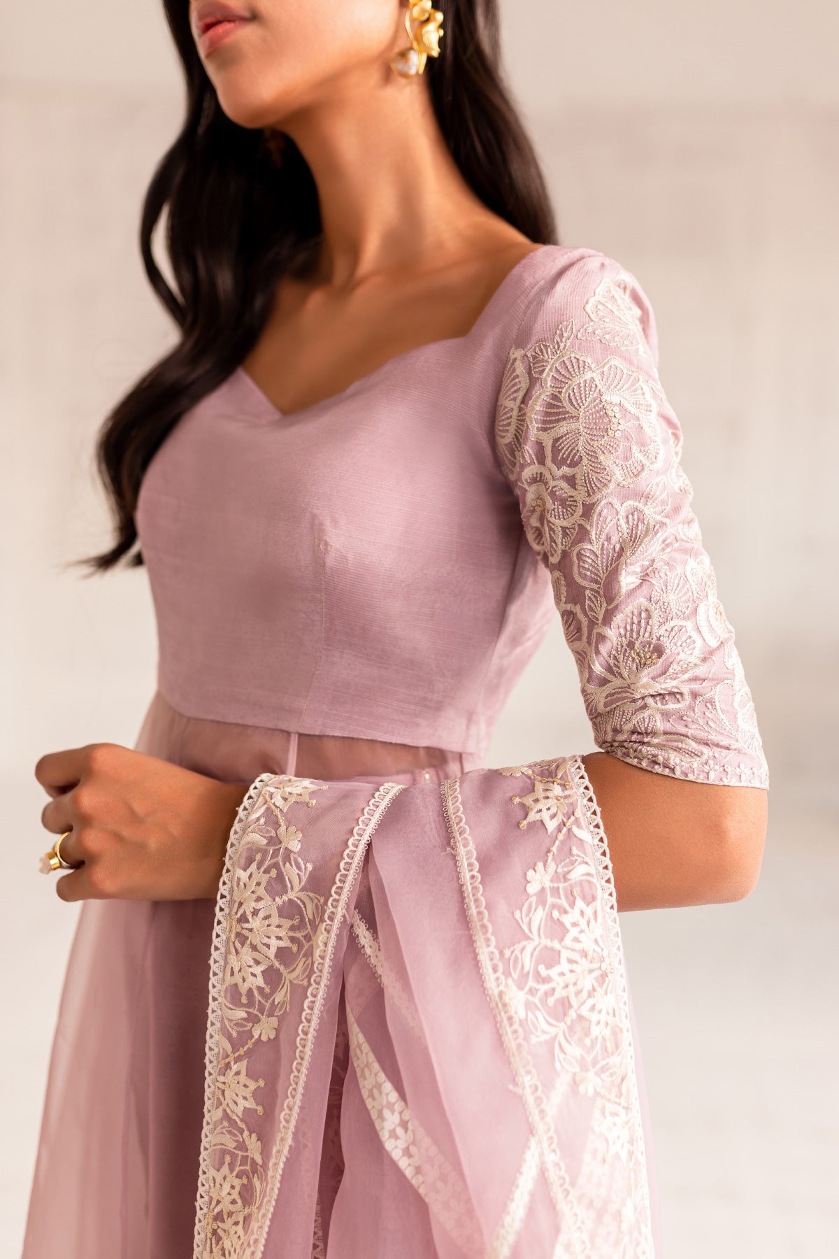 Model in a close-up shot wearing an organza light pink long flared pishwas paired with an organza dupatta