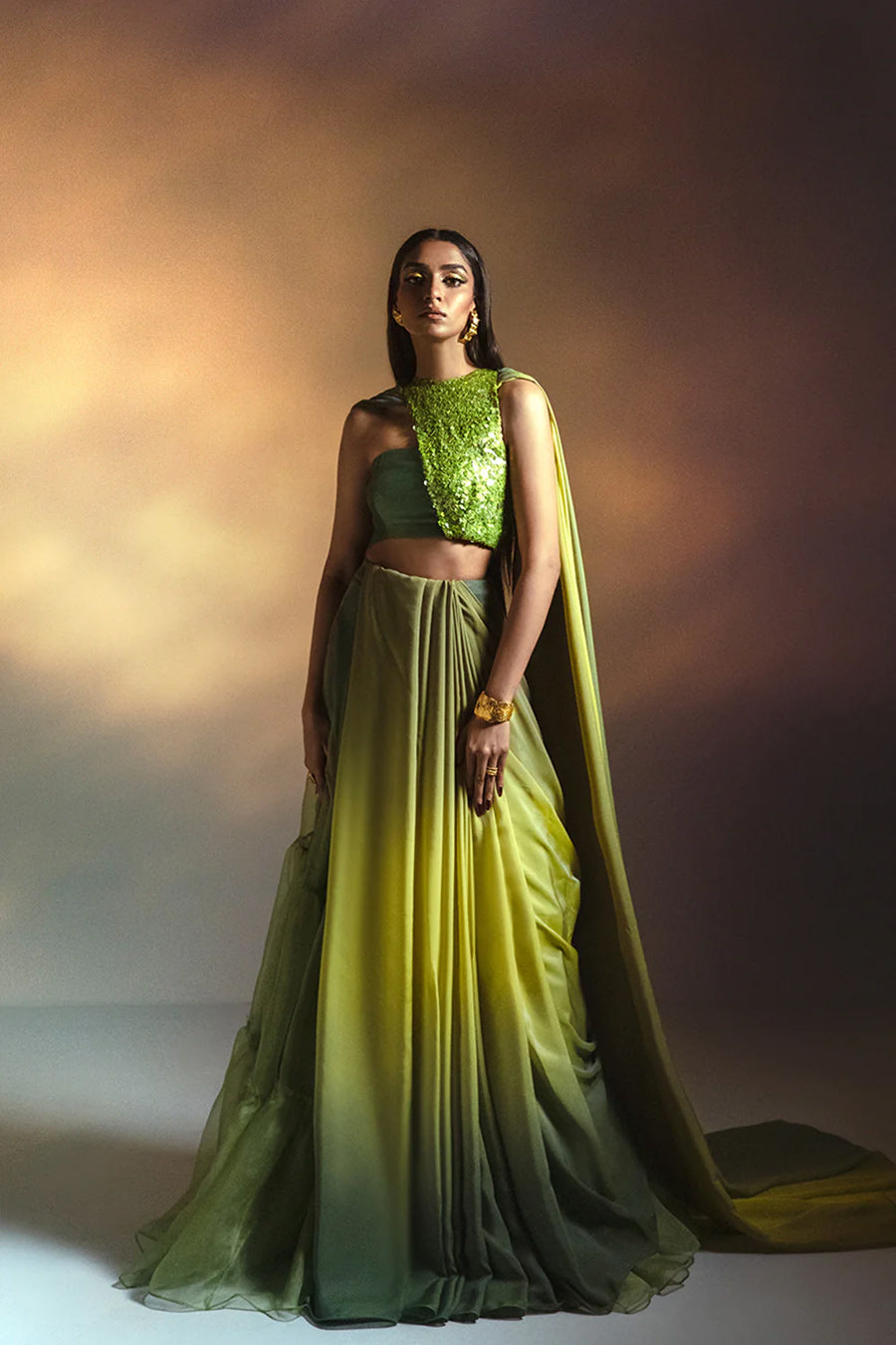 Model in a side view shot wearing a lime green halter blouse paired with an ombre drape in Italian chiffon silk and a ruffled silk organza skirt