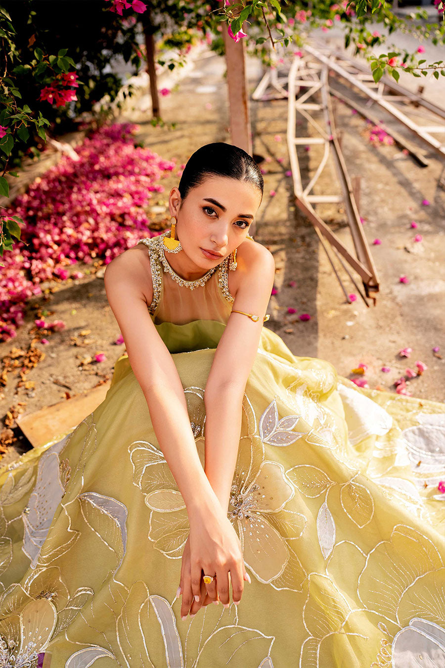 model in a seated top shot wearing a formal lime green lehenga paired with a blouse and dupatta