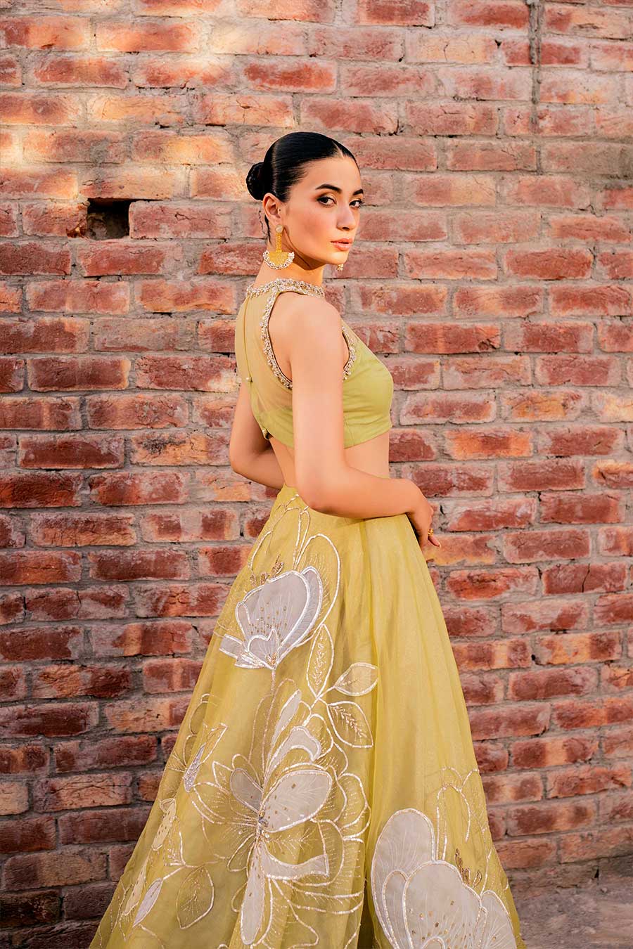 model in a side shot wearing a formal lime green lehenga paired with a blouse and dupatta 