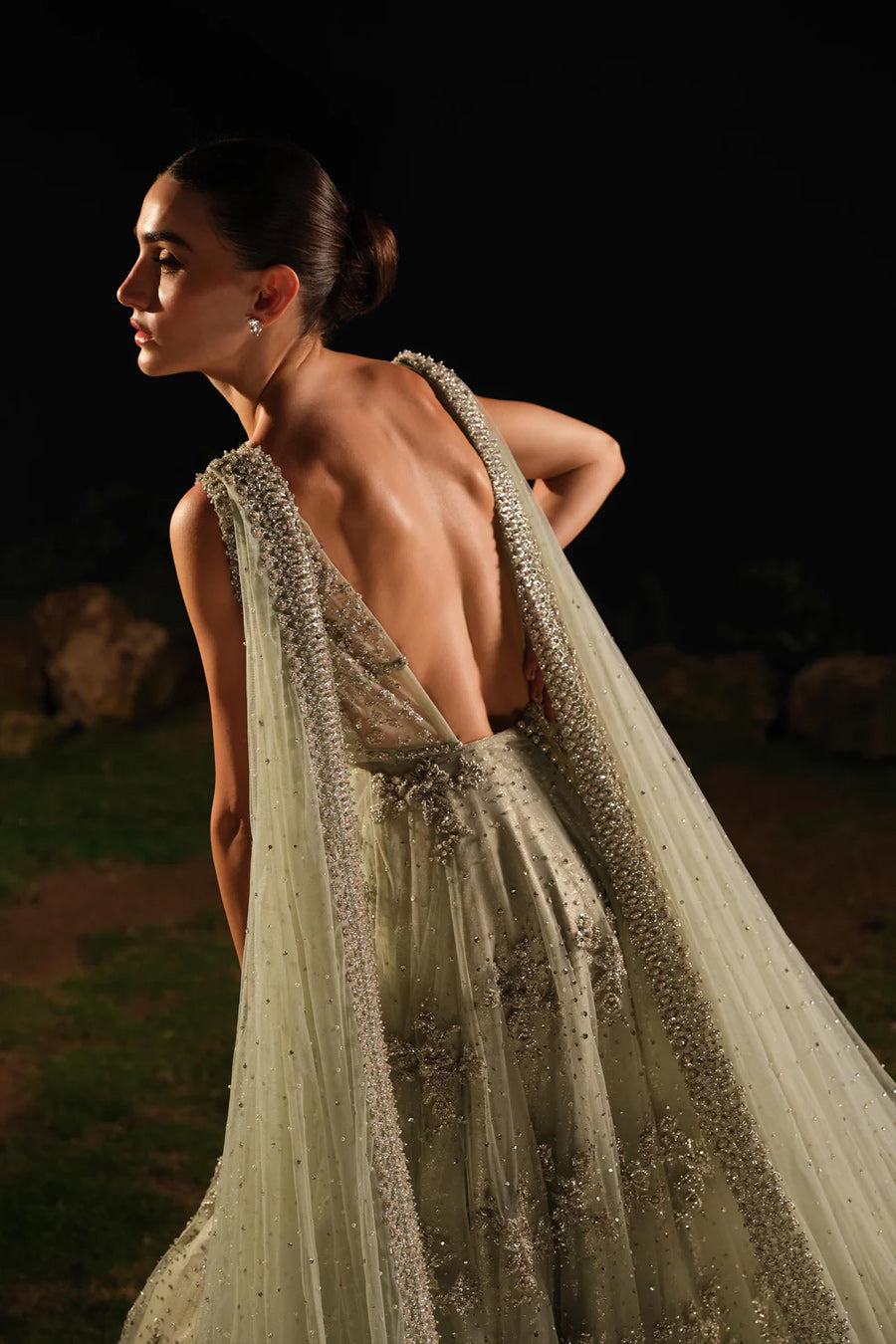 Model in a back closeup shot wearing mint green bridal gown with drapes attached to the shoulders