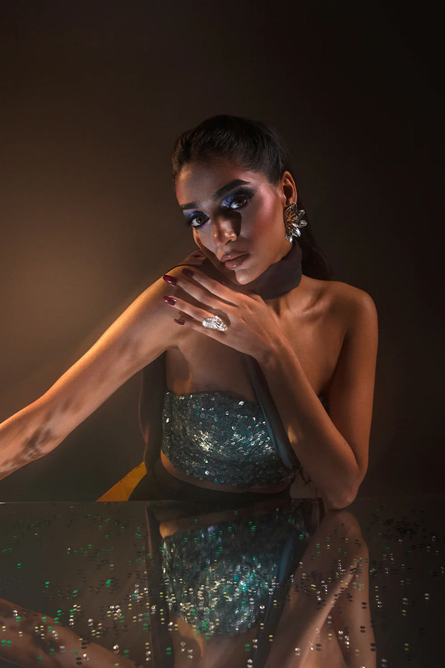 Model in a close-up shot of a multi-colored blue corset blouse embellished with sequins