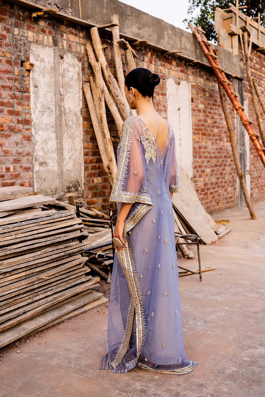 model in a back shot wearing a formal periwinkle net kaftan