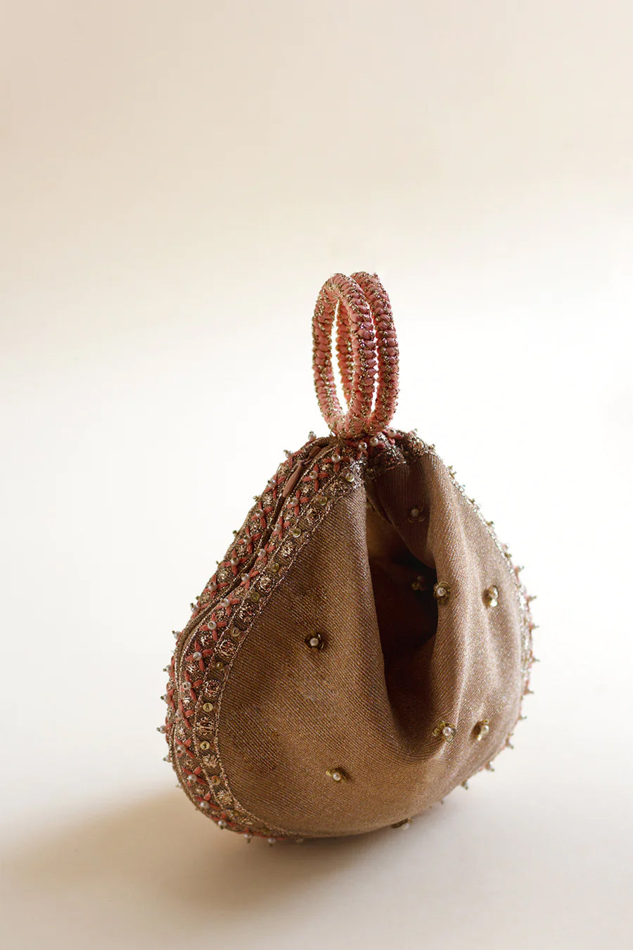 Full shot of pink zari pouch with silk thread and zardozi dori bangles