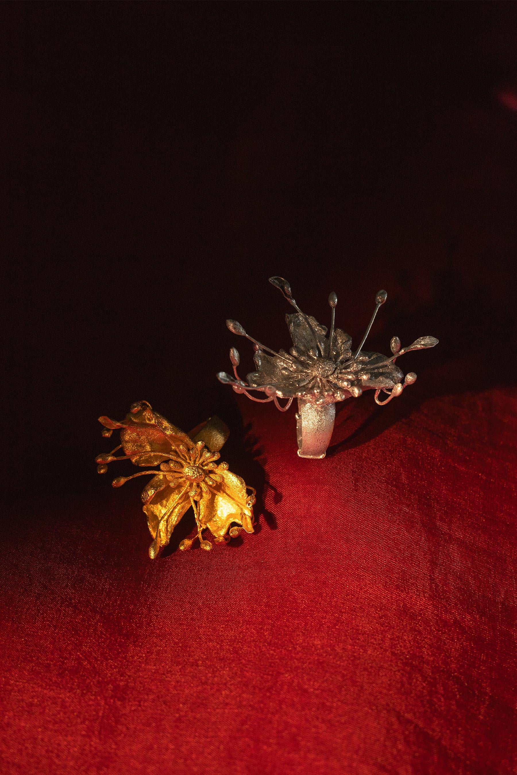 Full shot of golden ring and silver ring on a maroon background